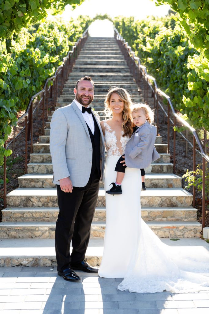 Whitney and Ty with son at base of staircase at Nella Terra