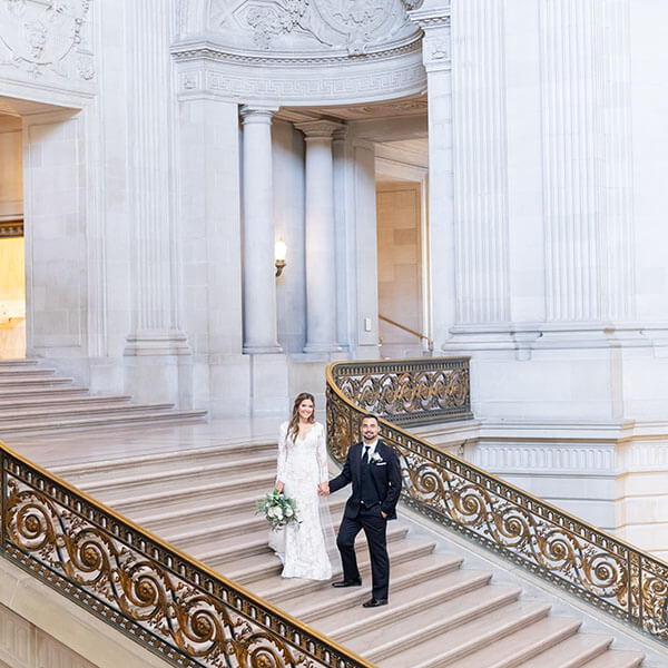bride and groom on steps of San Francisco City Hall
