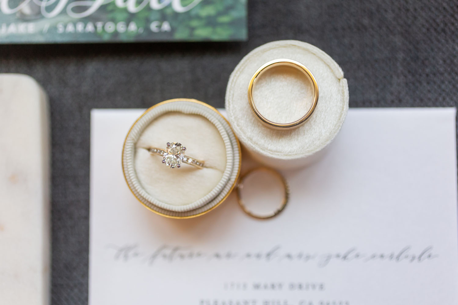 detail shot of wedding rings on top of invitation