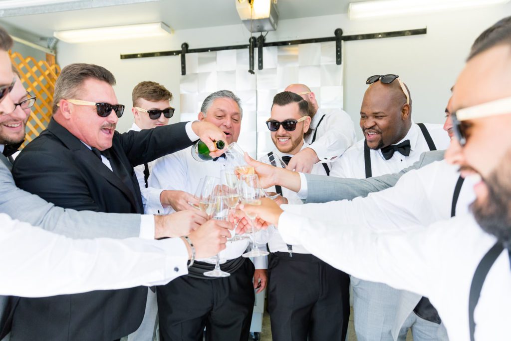 groom with groomsmen pouring champagne