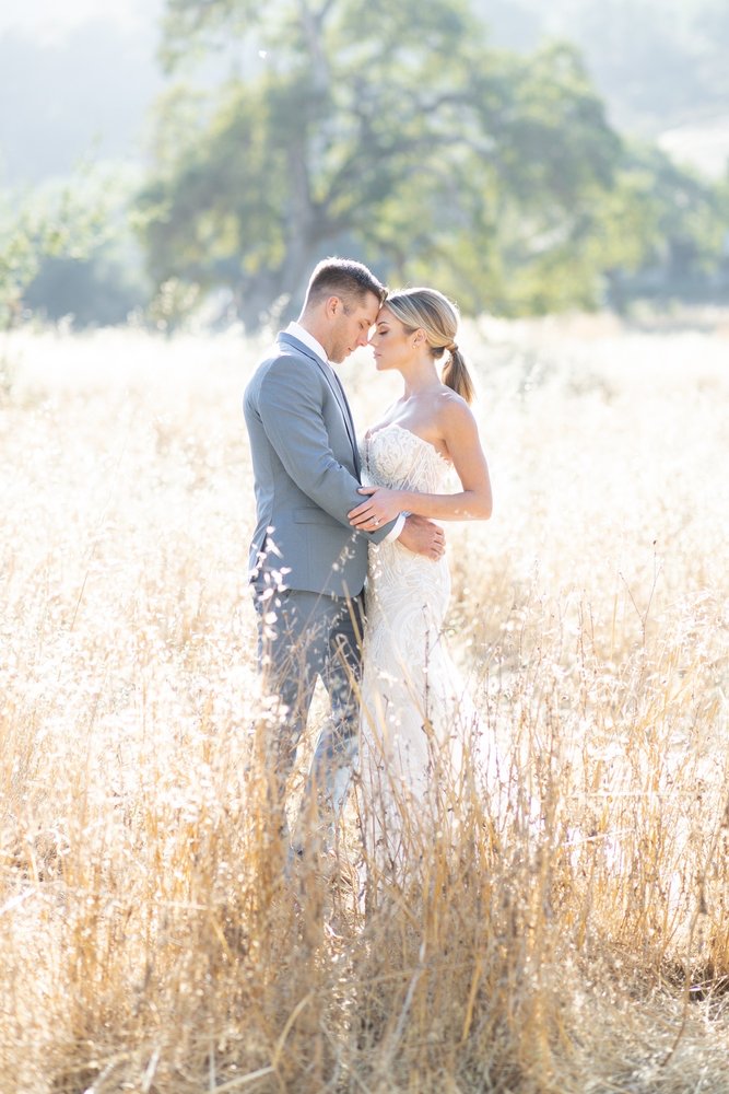 Wedding couple stand in field